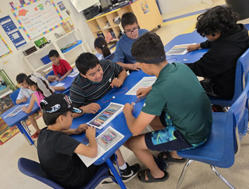 School-age children working together at tables at Kingston Academy