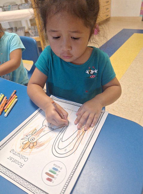 A Kingston child drawing with a marker