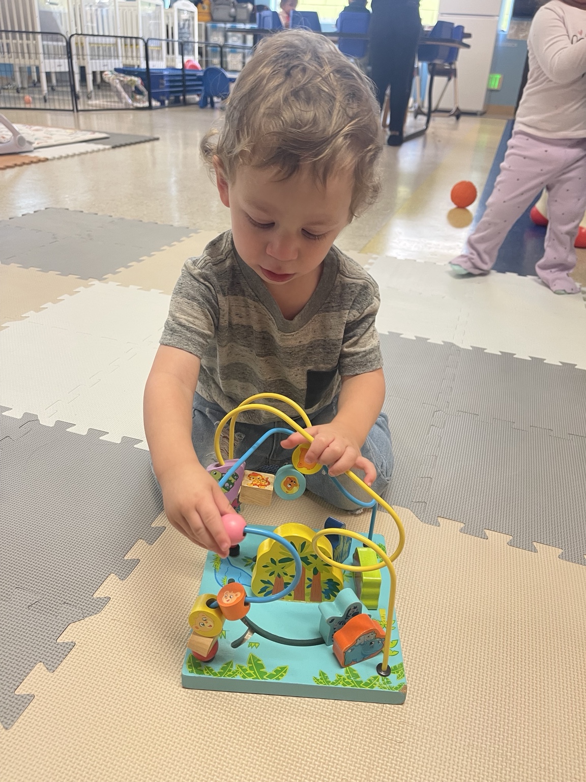 A child exploring a bead maze