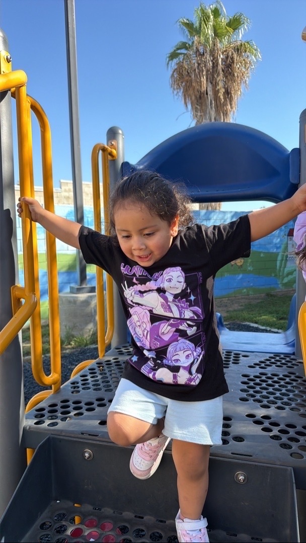 A child exploring the playground climbing steps
