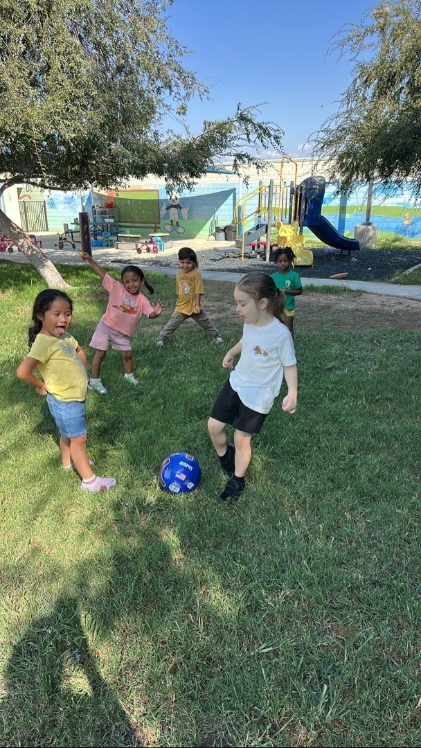Children playing with a ball together on the grass