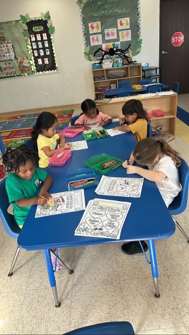 Children coloring together at classroom tables