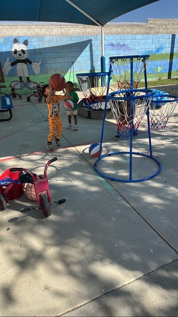 Children playing basketball with outdoor hoops