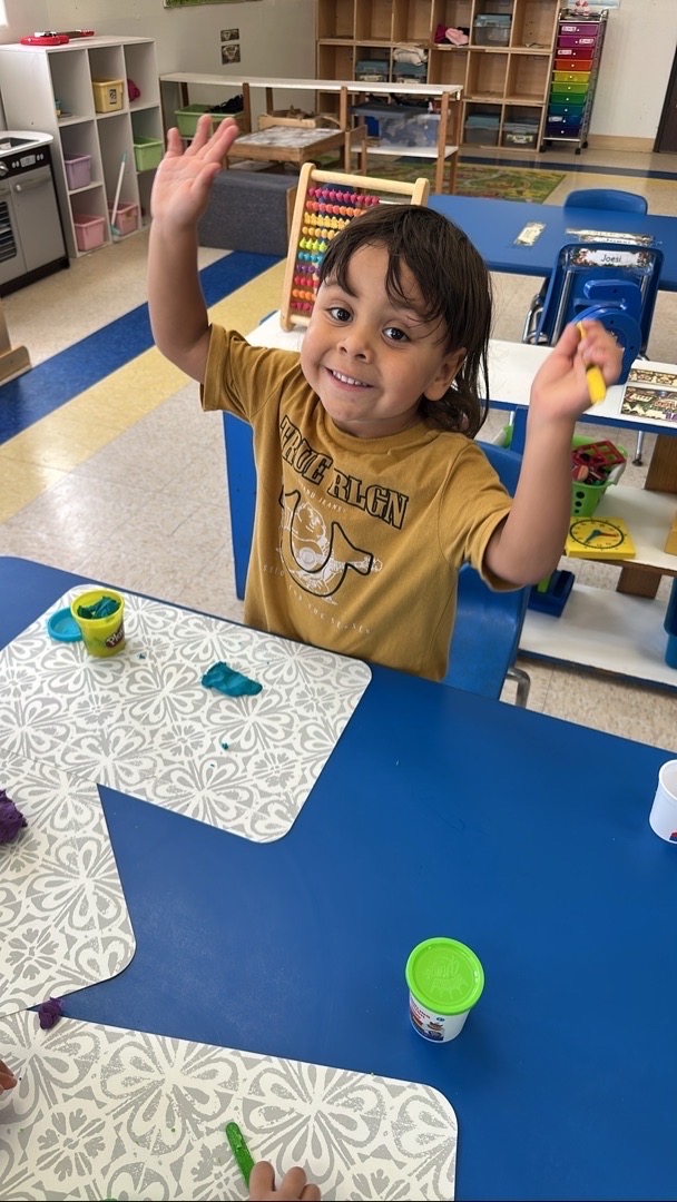 A child celebrating during a classroom table game