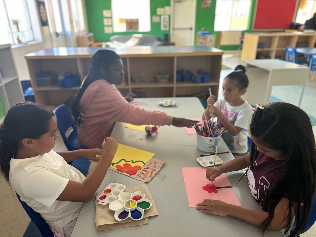 Children painting together with watercolor palettes