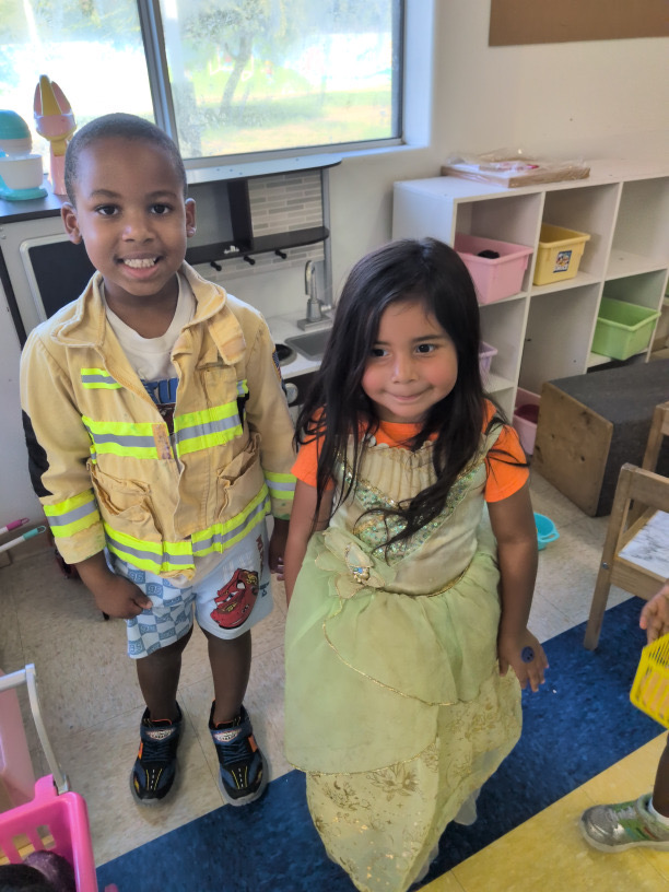 Two children enjoying firefighter and princess dress-up clothes