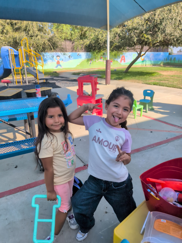 Two children posing playfully on the playground